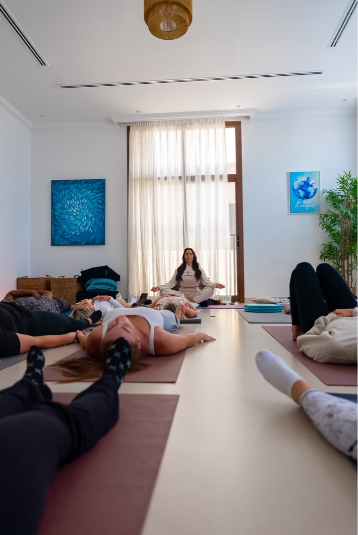 Shona kneeling beside a participant, offering gentle guidance